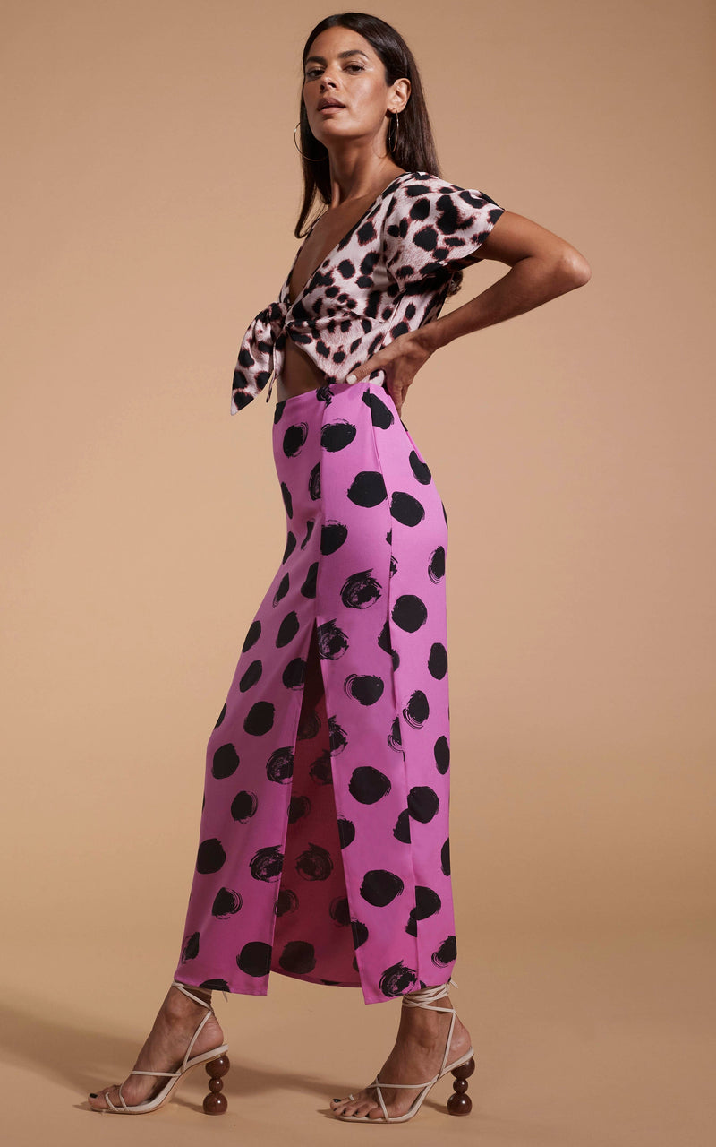 Dancing Leopard model wearing Lily Dress In Blush Leopard & Black On Pink Dot facing side on with hands on hips