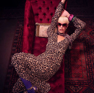 Dancing Leopard model lying on velvet sofa