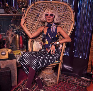 Dancing Leopard model sat in straw chair wearing spotted dress