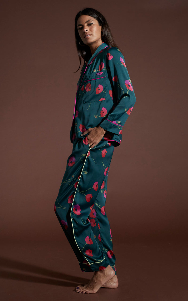 Dancing Leopard model wearing Cosmos Satin Long Leg PJ Set in Poppies on Dark Green posed side on with hand in pocket