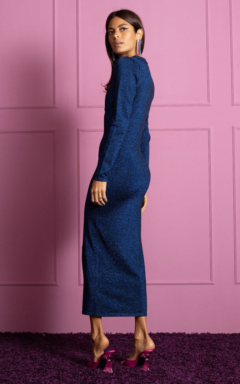 Dancing Leopard model standing with back to the camera wearing Gianna Metallic knit midi dress in blue with pink heels